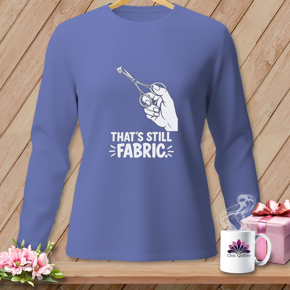 Long-sleeve purple shirt with a graphic of scissors cutting fabric and text that says "That's Still Fabric".