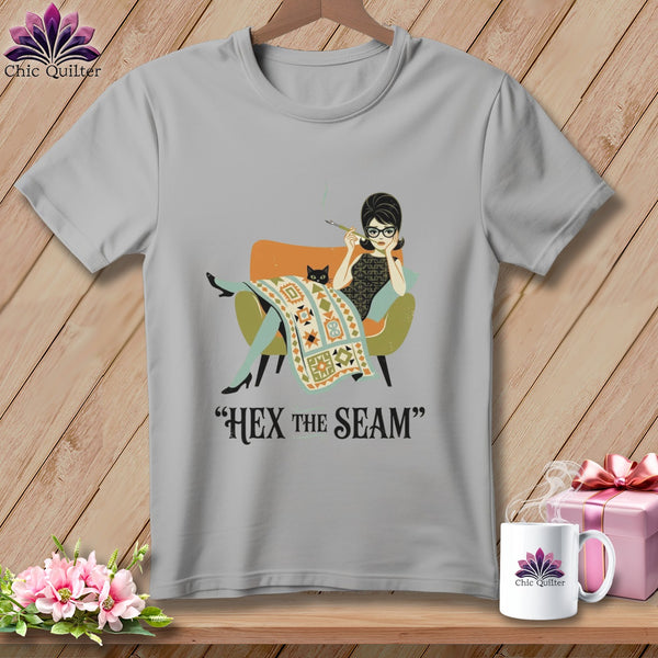 Gray t-shirt with illustration of a woman and cat and text "HEX THE SEAM".