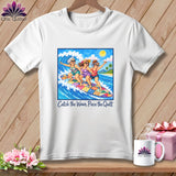 White t-shirt featuring three women surfing on a patchwork surfboard and the text Catch the Wave, Piece the Quilt.