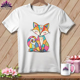 White t-shirt displayed on a wooden surface with a colorful patchwork fox graphic.