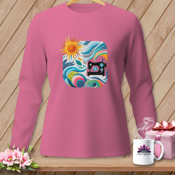 A pink long-sleeved shirt with a square quilted graphic of a sewing machine and sun.