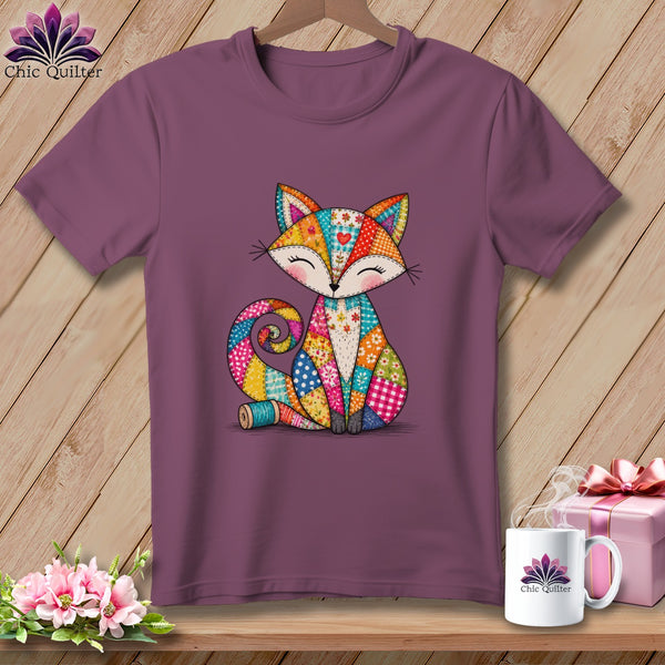 Purple crewneck t-shirt featuring a colorful patchwork fox graphic, displayed on a wooden surface.