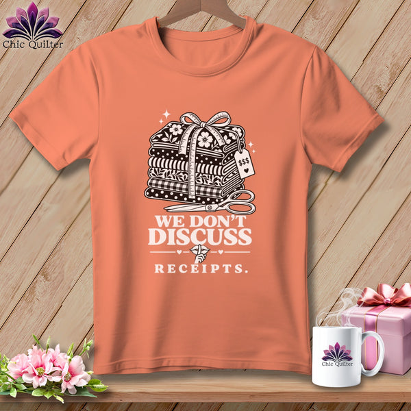 Coral t-shirt with fabric stack graphic and "We Don't Discuss Receipts" text.