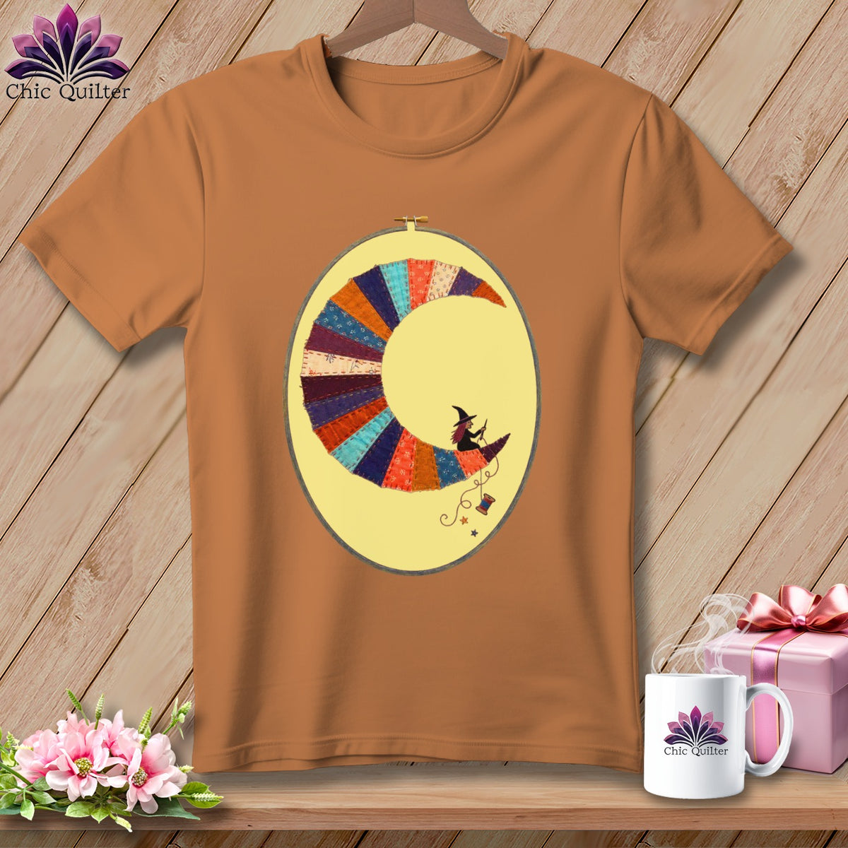 Orange t-shirt with a crescent moon quilt design featuring a witch and thread.