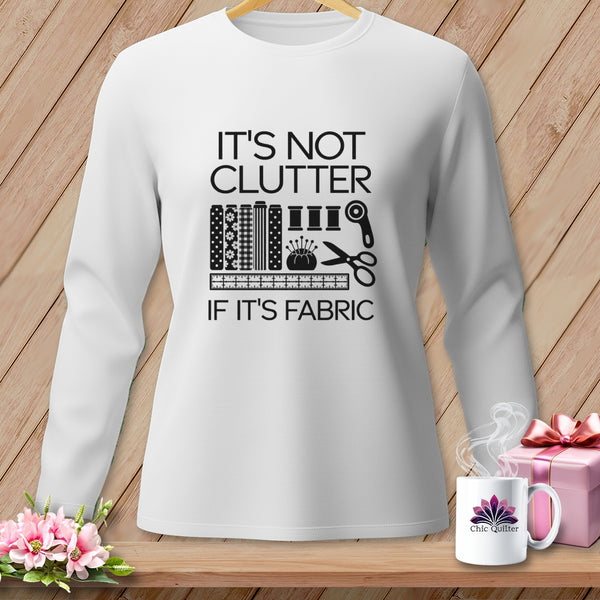 White long-sleeve shirt with "It's Not Clutter If It's Fabric" text and sewing icons.