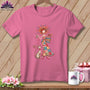 Pink crewneck t-shirt featuring a whimsical woman holding sewing supplies and a cat, hanging on a wooden background.