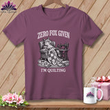 T-shirt with a fox lounging with a quilt, sewing machine, and text 