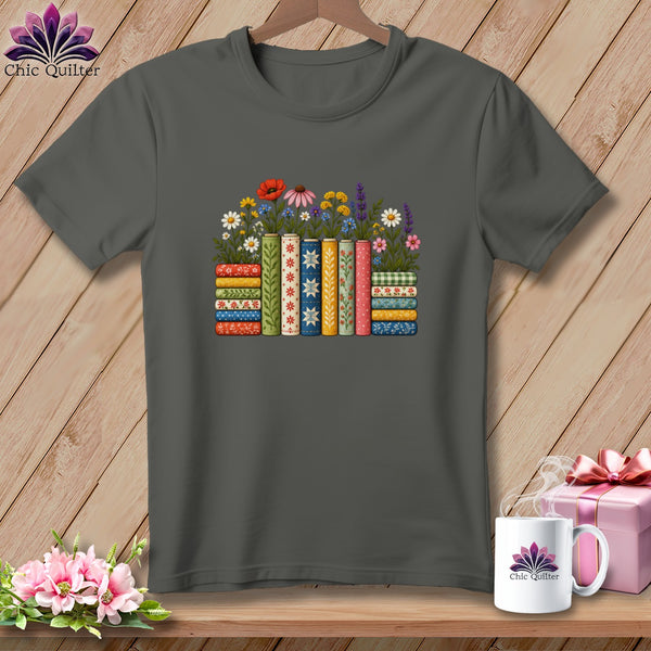 Dark gray t-shirt featuring a stack of colorful, patterned books topped with wildflowers.
