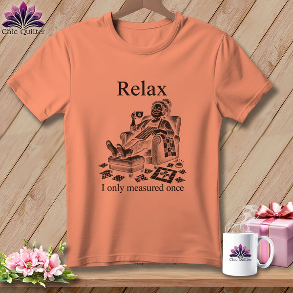 Peach t-shirt with "Relax" and sketch of person with cup and sewing items.