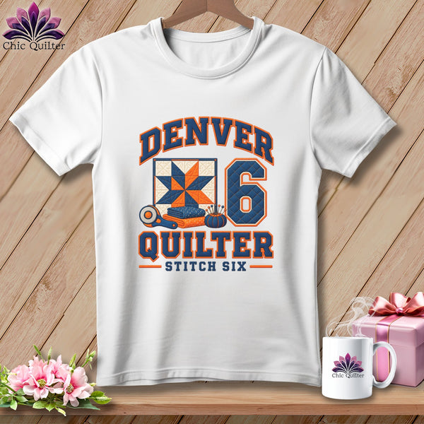 White t-shirt featuring a Denver Quilter graphic with a quilt block, number six, and sewing tools.