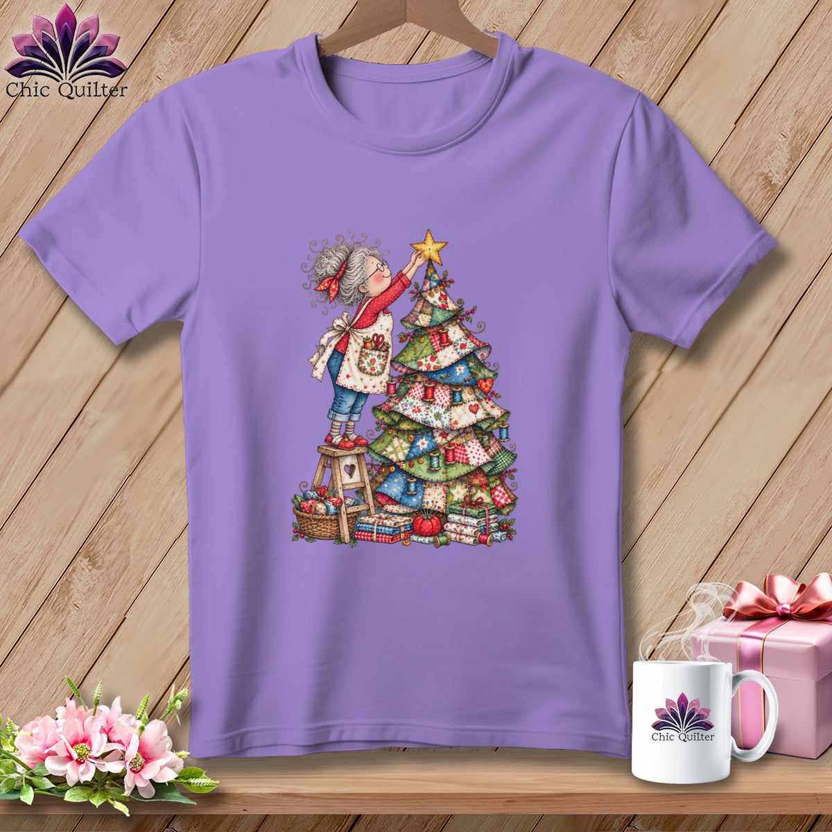 Light purple crewneck t-shirt featuring an illustration of an older woman decorating a patchwork Christmas tree.
