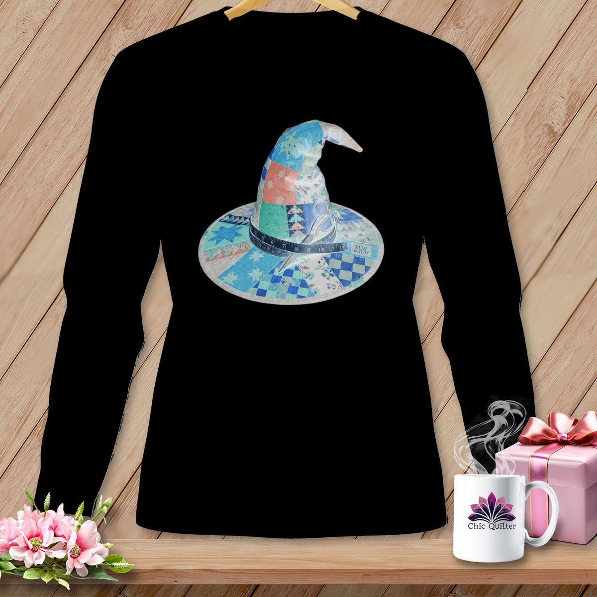 Black long-sleeve shirt with a patchwork witch hat design featuring scissors and a measuring tape.