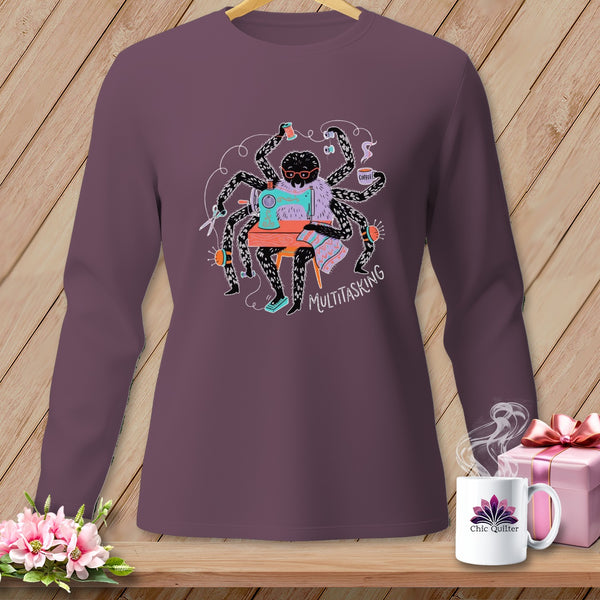 Spider with multiple arms sewing, text "MULTITASKING" on purple long sleeve shirt.