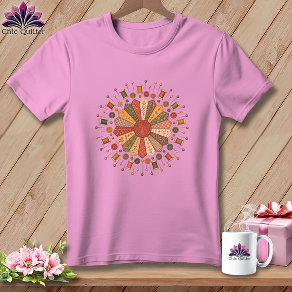Pink t-shirt with a circular quilt design featuring spools of thread and buttons.