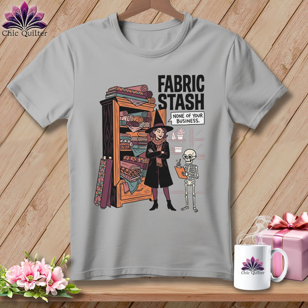 Gray t-shirt with witch and skeleton standing next to a fabric stash.