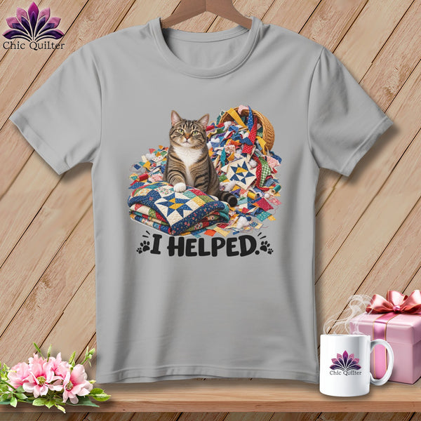 Tabby cat sits on quilts surrounded by fabric scraps and text "I HELPED."