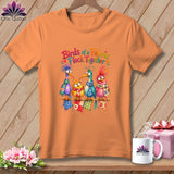 Orange t-shirt featuring four colorful cartoon birds wearing scarves, sitting together with quilt blocks.