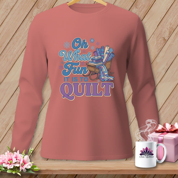 Long-sleeve shirt with "Oh What Fun It Is To Quilt" text and a sleigh filled with fabric rolls.