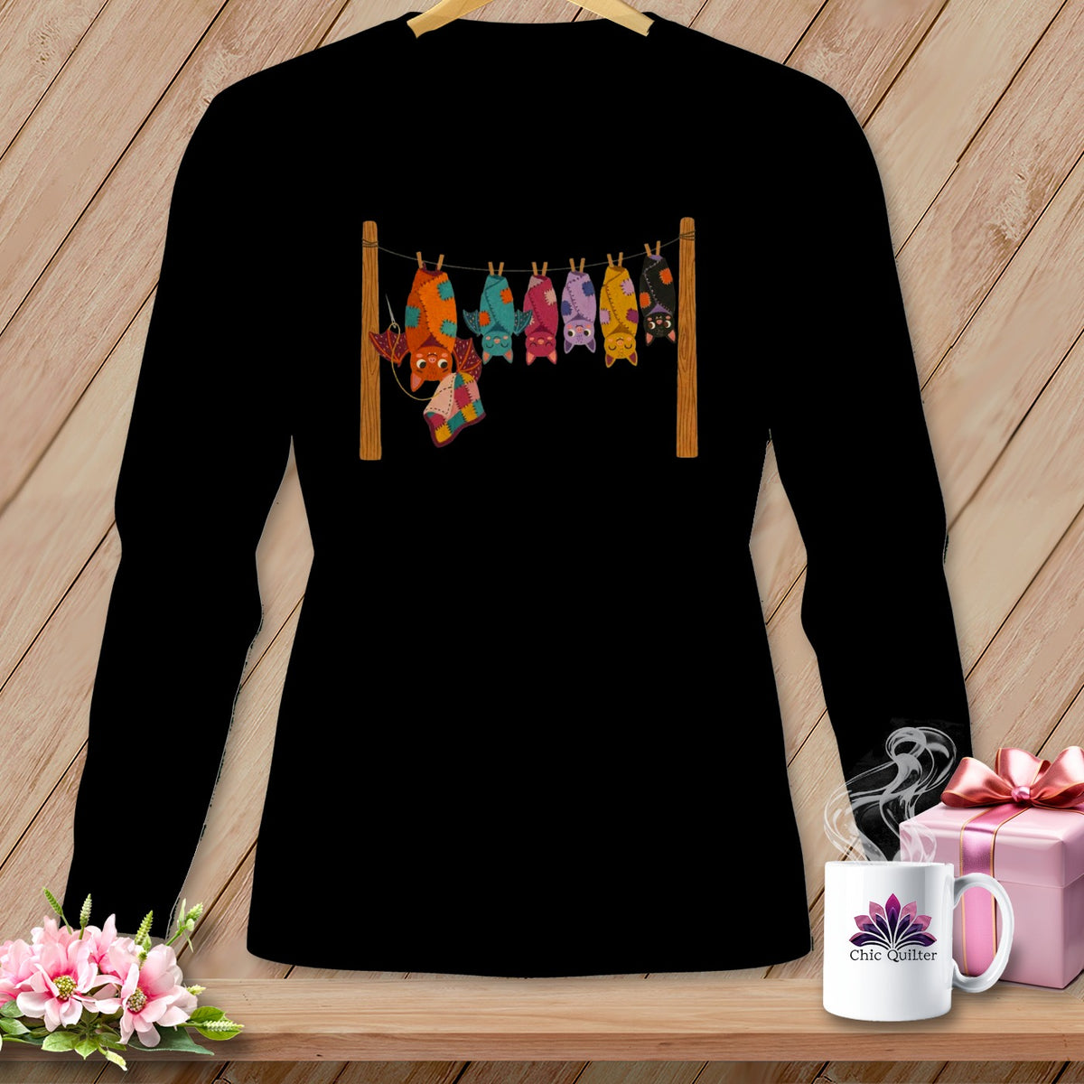 Black t-shirt with colorful patchwork bats hanging on a clothesline.