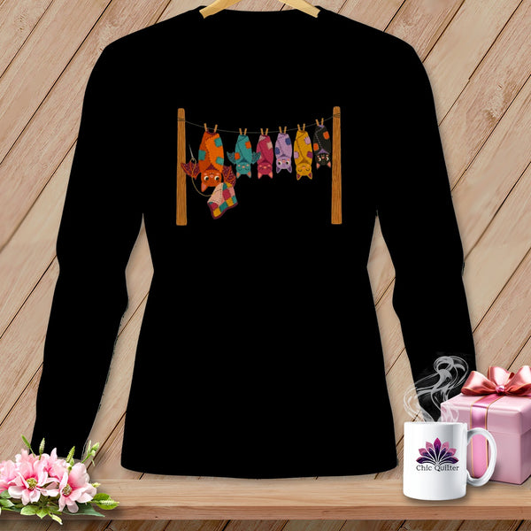 Black t-shirt with colorful patchwork bats hanging on a clothesline.