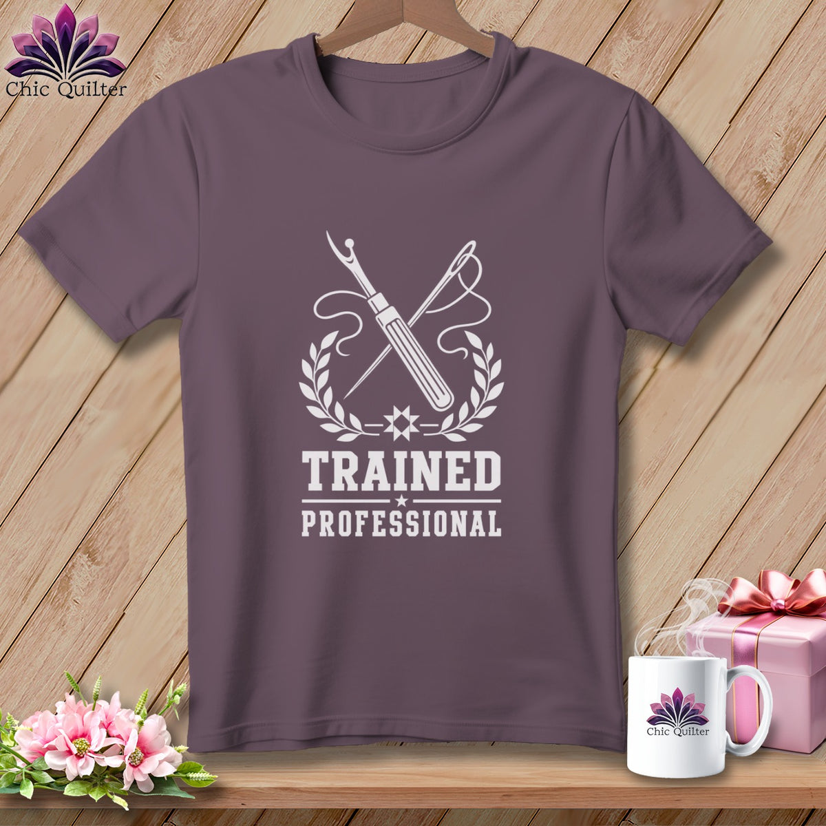 Purple t-shirt with sewing tools, laurel wreath, and text "Trained Professional".