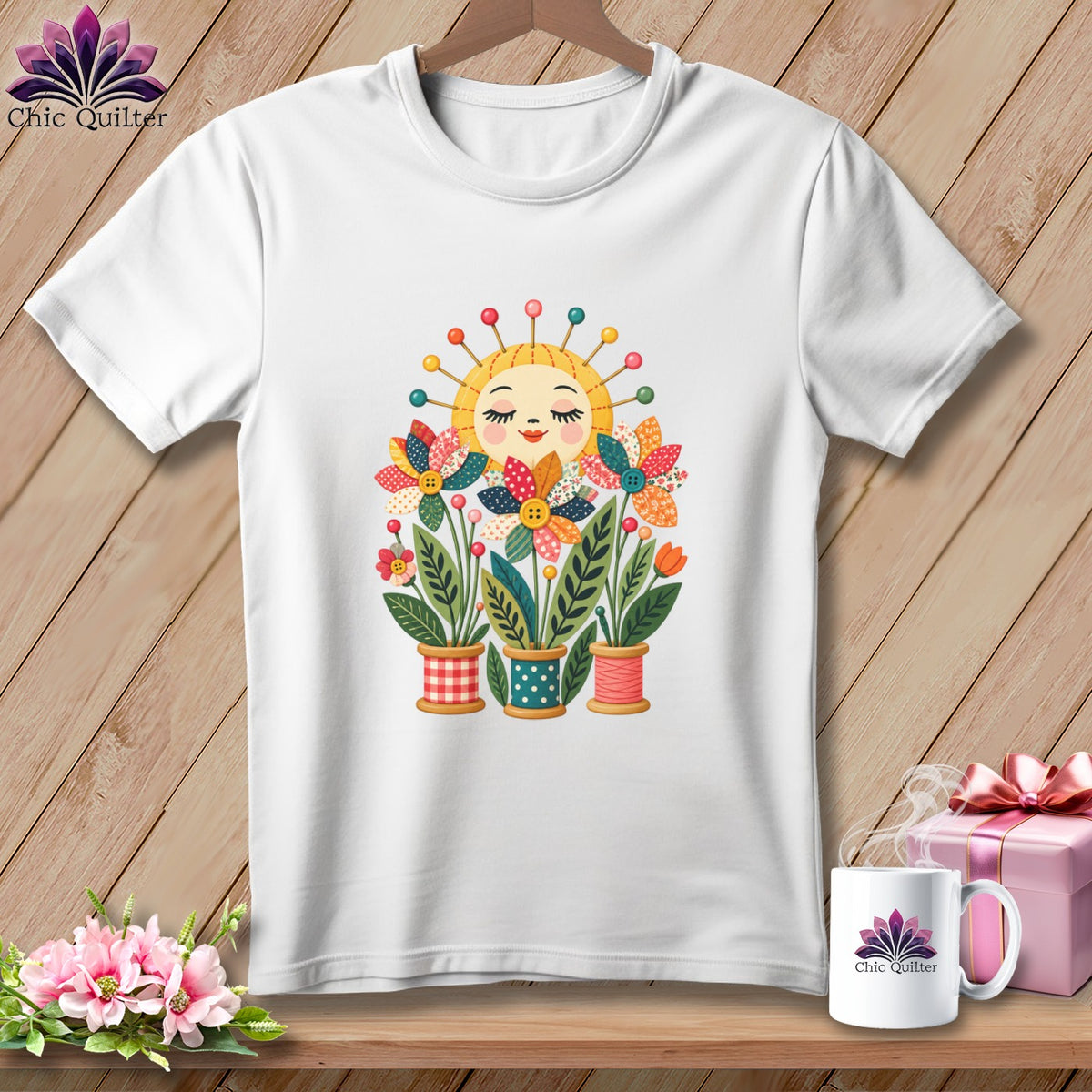 A white t-shirt features a colorful graphic of a smiling sun and flowers planted in spools of thread.