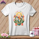 A white t-shirt features a colorful graphic of a smiling sun and flowers planted in spools of thread.