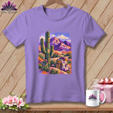 Purple crewneck t-shirt featuring a colorful painted desert scene with mountains, a saguaro cactus, and quilts.