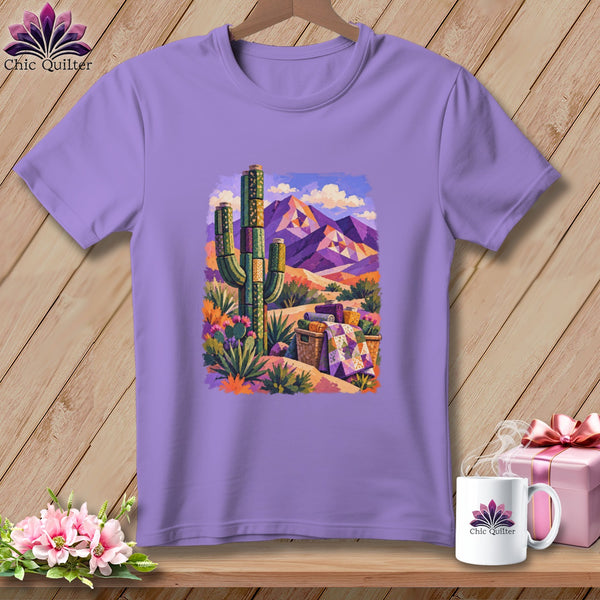 Purple crewneck t-shirt featuring a colorful painted desert scene with mountains, a saguaro cactus, and quilts.