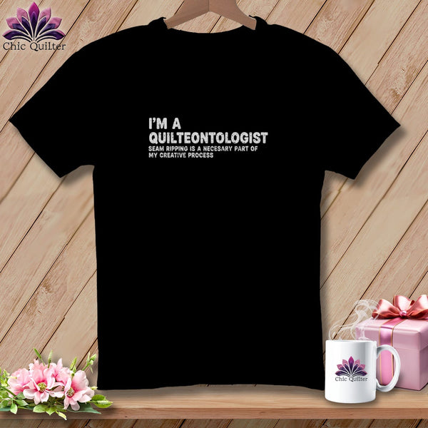 Black t-shirt with "I'M A QUILTEONTOLOGIST" text and floral logo.