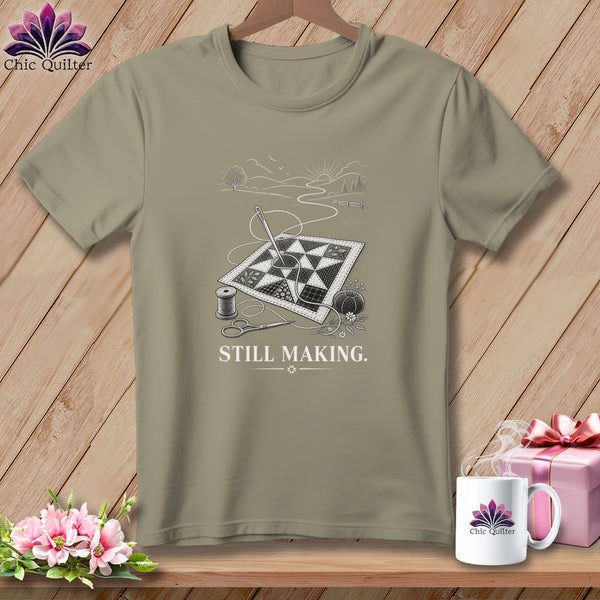 T-shirt with a quilt, sewing needle, thread, scissors, and the text "STILL MAKING."
