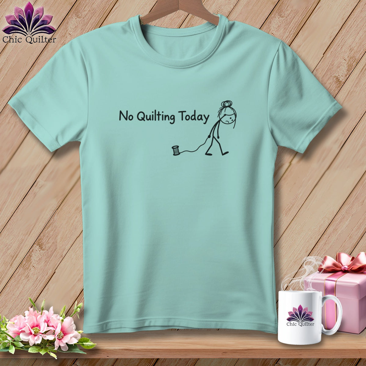 Light blue t-shirt with a stick figure and spool of thread, saying "No Quilting Today".
