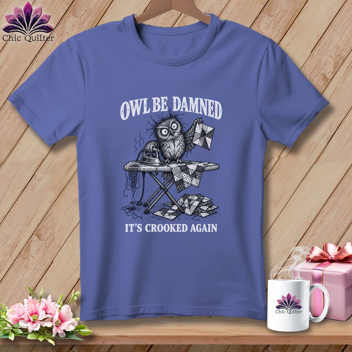 T-shirt with a graphic of a disheveled owl ironing a crooked quilt piece.