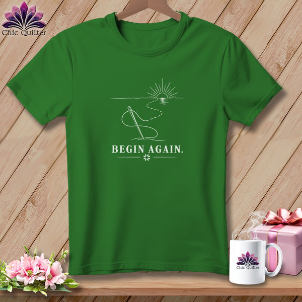 Green t-shirt with "BEGIN AGAIN." text and sewing needle design.