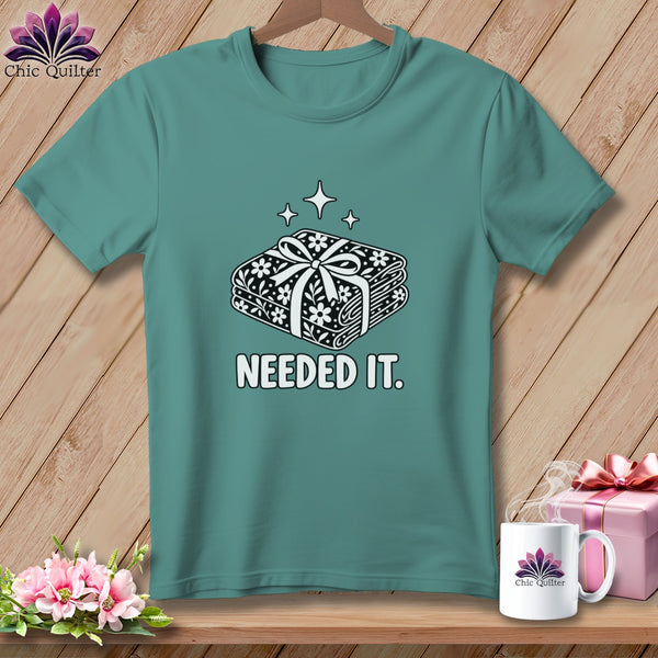 Teal t-shirt with a graphic of fabric bundle and the text "NEEDED IT."