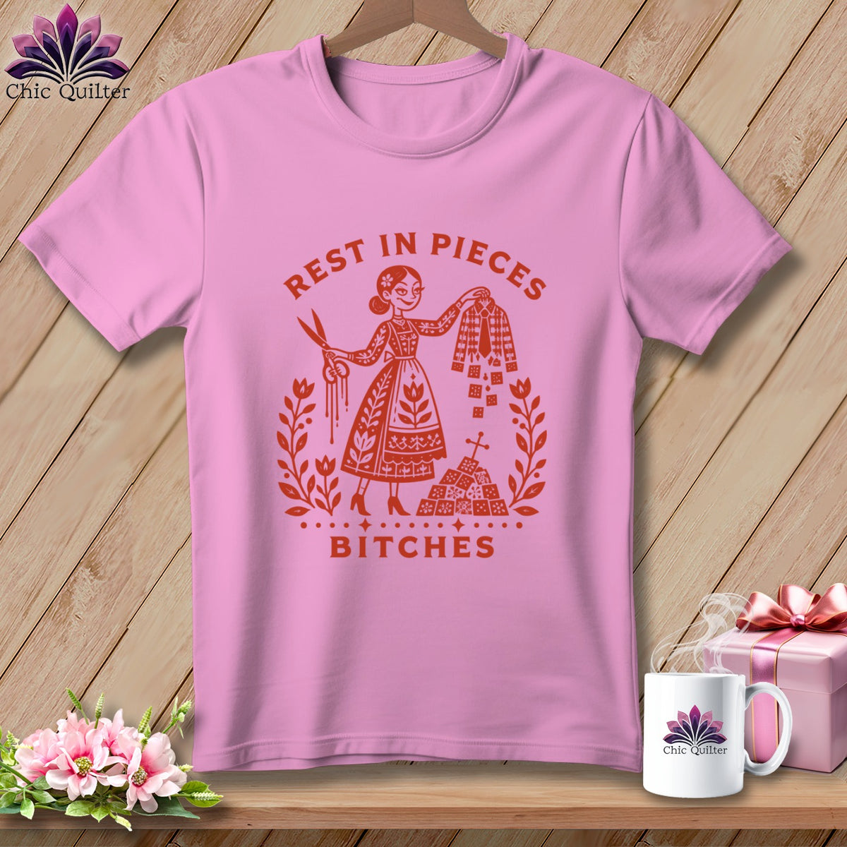 Pink t-shirt with "Rest in Pieces Bitches" text and graphic of woman with scissors and fabric.