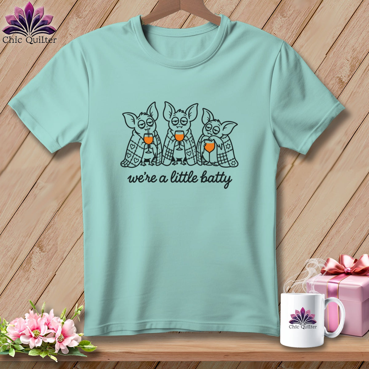 Mint t-shirt with three cartoon bats holding wine glasses, text "we're a little batty."