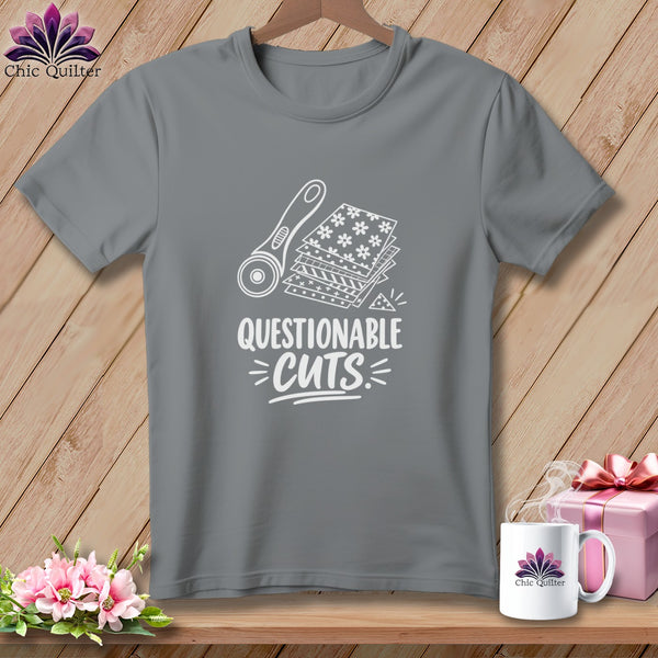 Gray t-shirt with white graphic of rotary cutter, fabric stack, and text "Questionable Cuts".