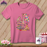 Pink t-shirt featuring a graphic of four colorful giraffes wearing sunglasses with stacked fabrics and a quilt.