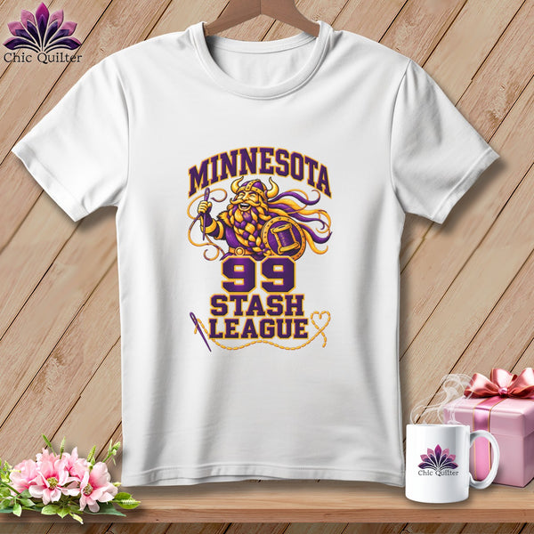 White t-shirt featuring a cartoon Viking design with the text "Minnesota 99 Stash League" hanging on a wooden wall.