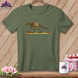An olive green t-shirt displays an illustration of a dinosaur skeleton wearing a patchwork quilt.