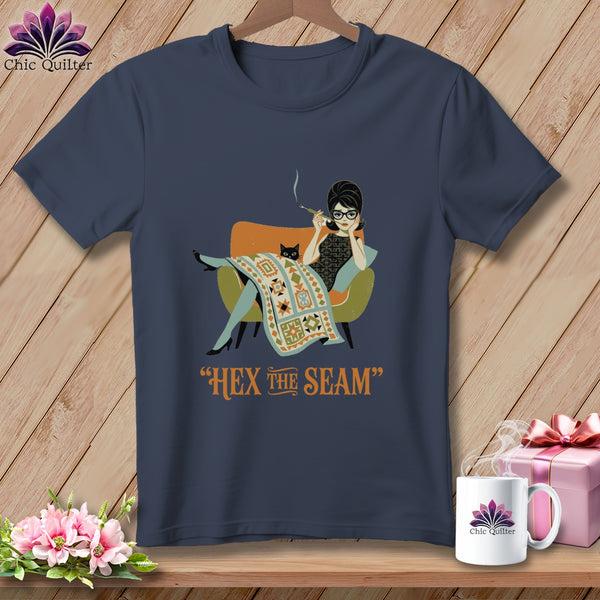 T-shirt graphic of woman with cat and quilt, reads "Hex the Seam".