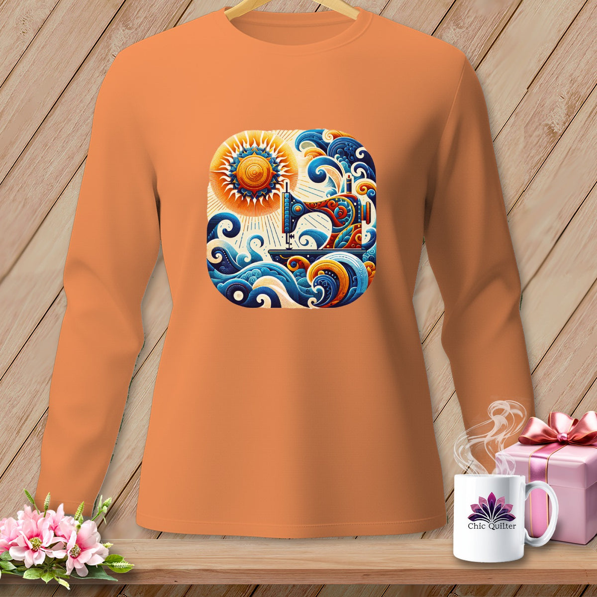 Orange long-sleeve shirt with a colorful sewing machine, sun, and wave graphic.