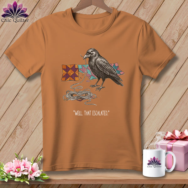 T-shirt with raven tangled in string next to quilt pieces and text.