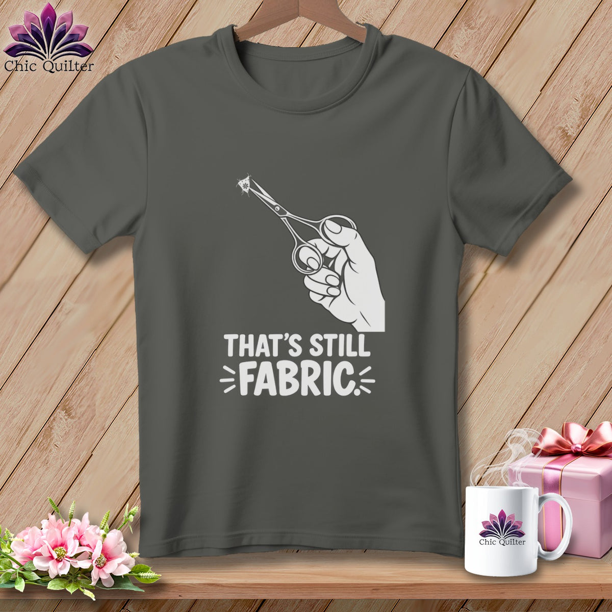 Dark gray t-shirt with white graphic of scissors cutting "That's Still Fabric".