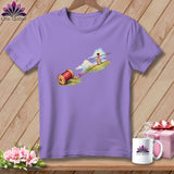 A purple t-shirt featuring a whimsical illustration of a girl tightrope walking on red thread.