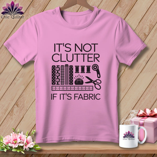 Pink t-shirt with "IT'S NOT CLUTTER IF IT'S FABRIC" and sewing graphic.