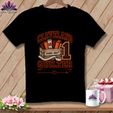 Black t-shirt featuring a Cleveland Quilter graphic with fabric rolls, a measuring tape, and text.