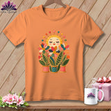An orange t-shirt displays a graphic of a smiling sun and colorful fabric flowerpots.