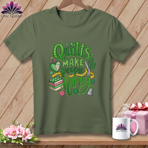 An olive green t-shirt with green text reading Quilts Make People Happy surrounded by sewing motifs.